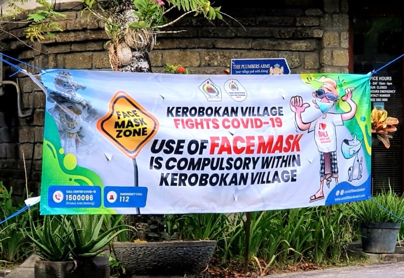 A banner in Kerobokan Village, Bali, notifying passes by to wear their masks during the COVID-19 Pandemic.