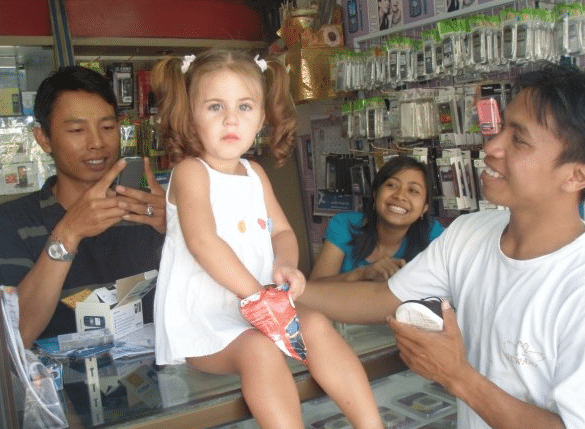 Lee Anna’s daughter, Shanti, being admired by Balinese locals at a SIM card store.