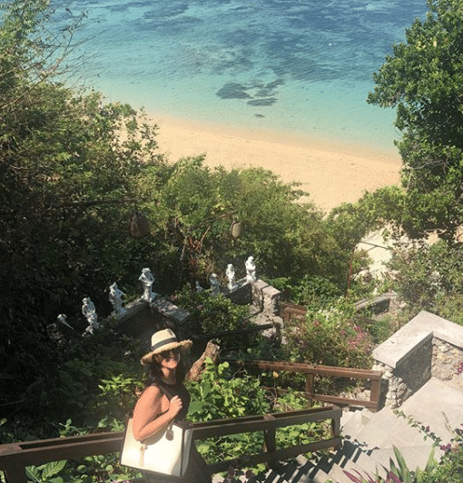 Karlie Cummins descending an ornamented Balinese staircase to her local beach.