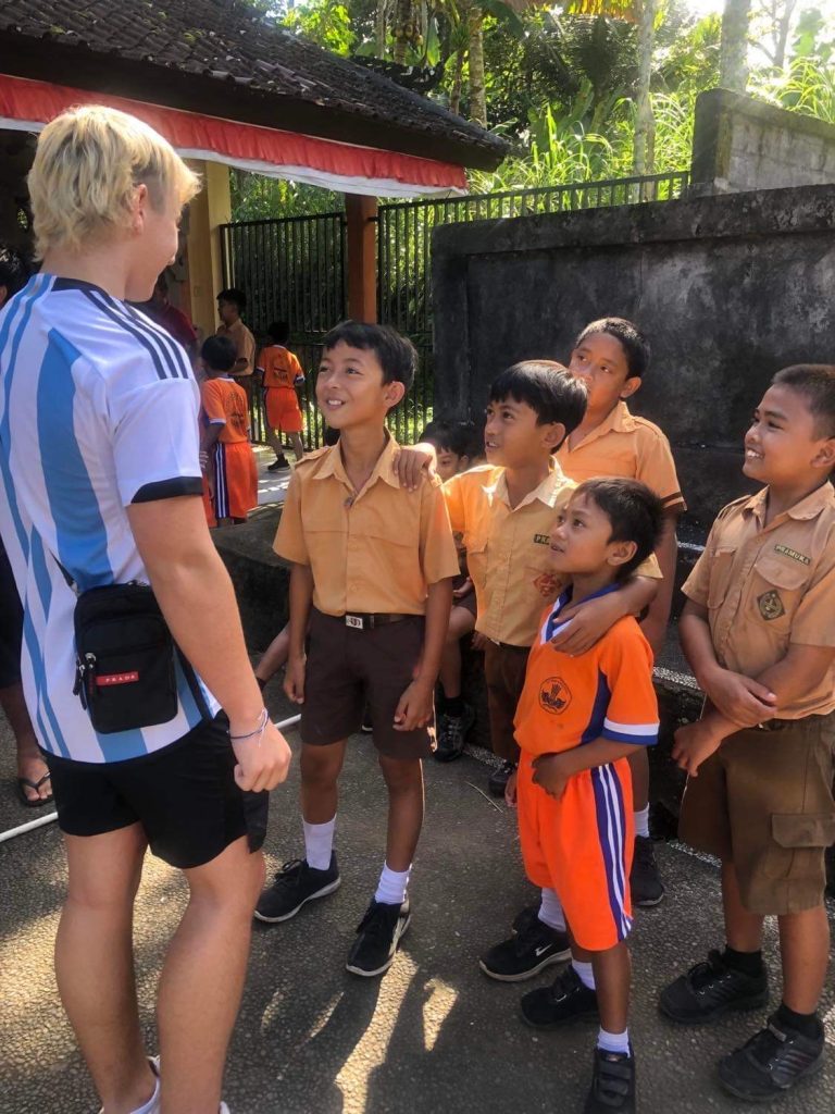 Teenage boy chatting to the local Balinese school kids